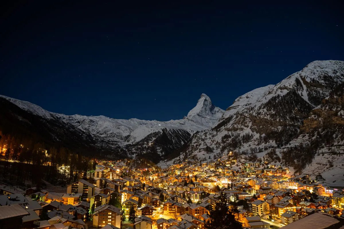 Zermatt à noite, com o Matterhorn iluminado ao fundo
