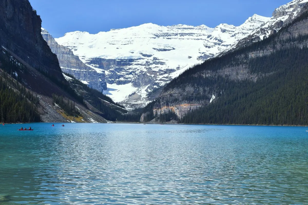 Águas azuis de Lake Louise com picos nevados ao fundo