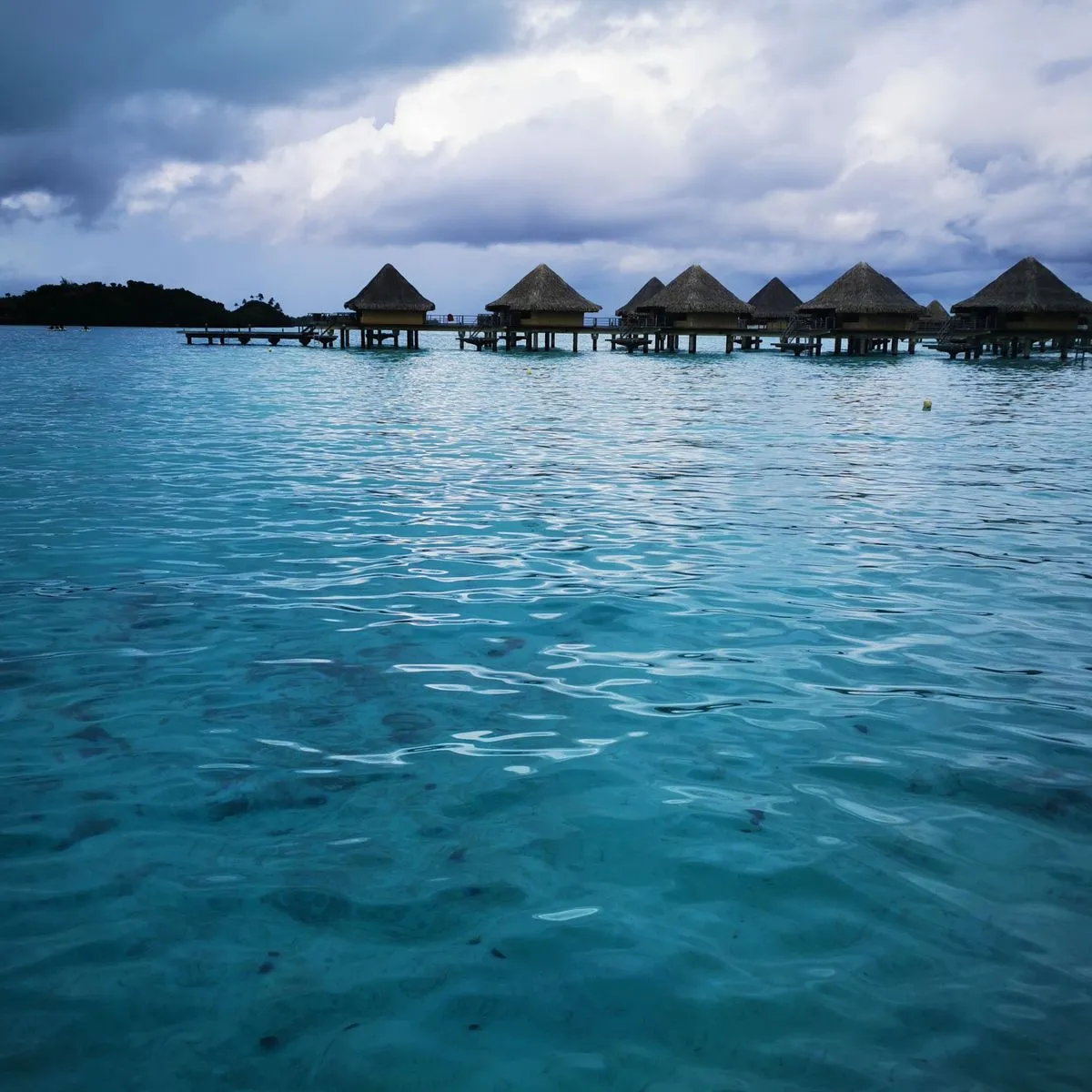 Bangalôs sobre a água na lagoa turquesa de Bora Bora