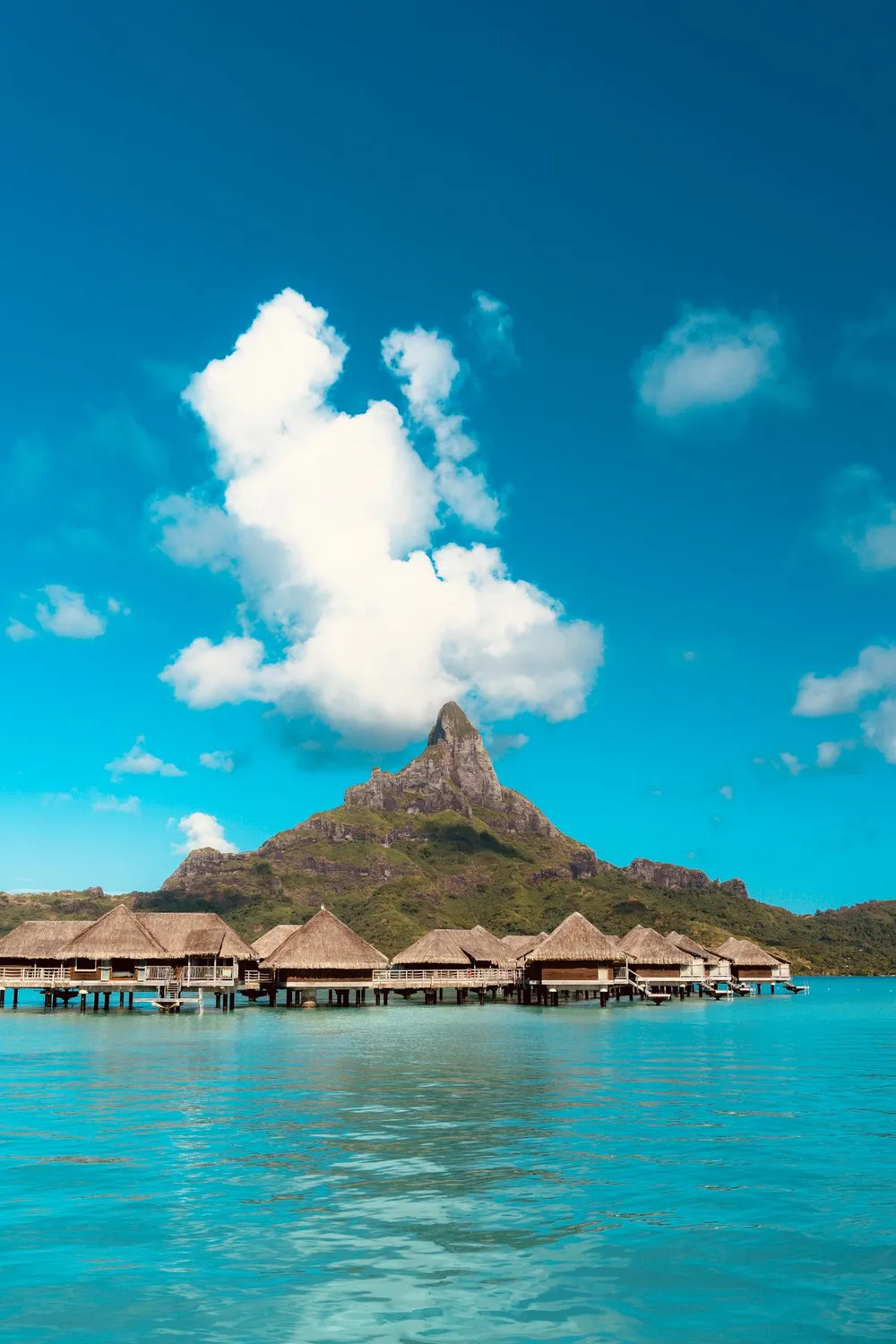 Bangalôs sobre a água com montanha ao fundo em Bora Bora