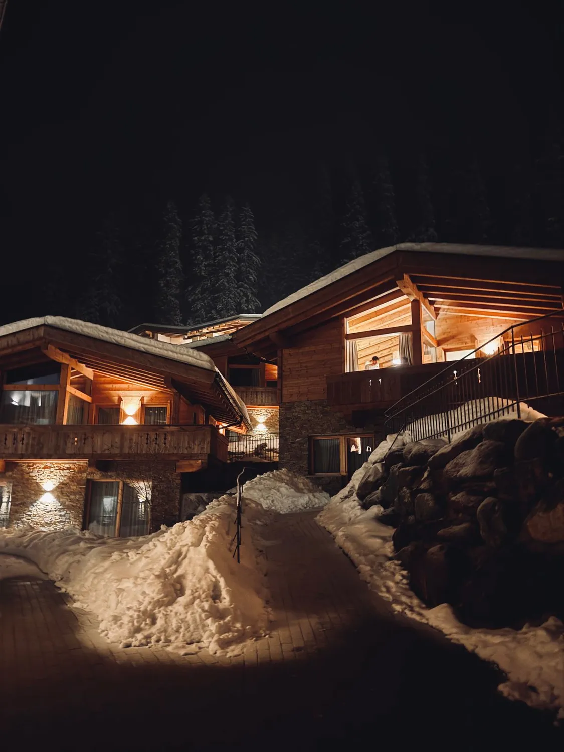 Chalé alpino iluminado à noite na neve