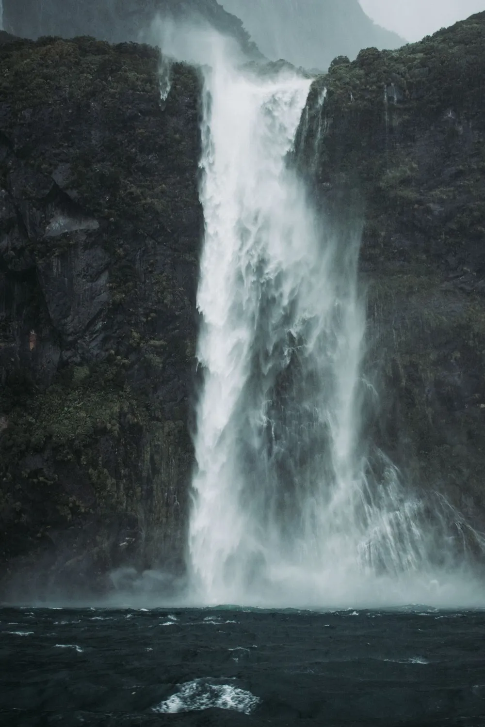 Cachoeira despencando no mar em Milford Sound