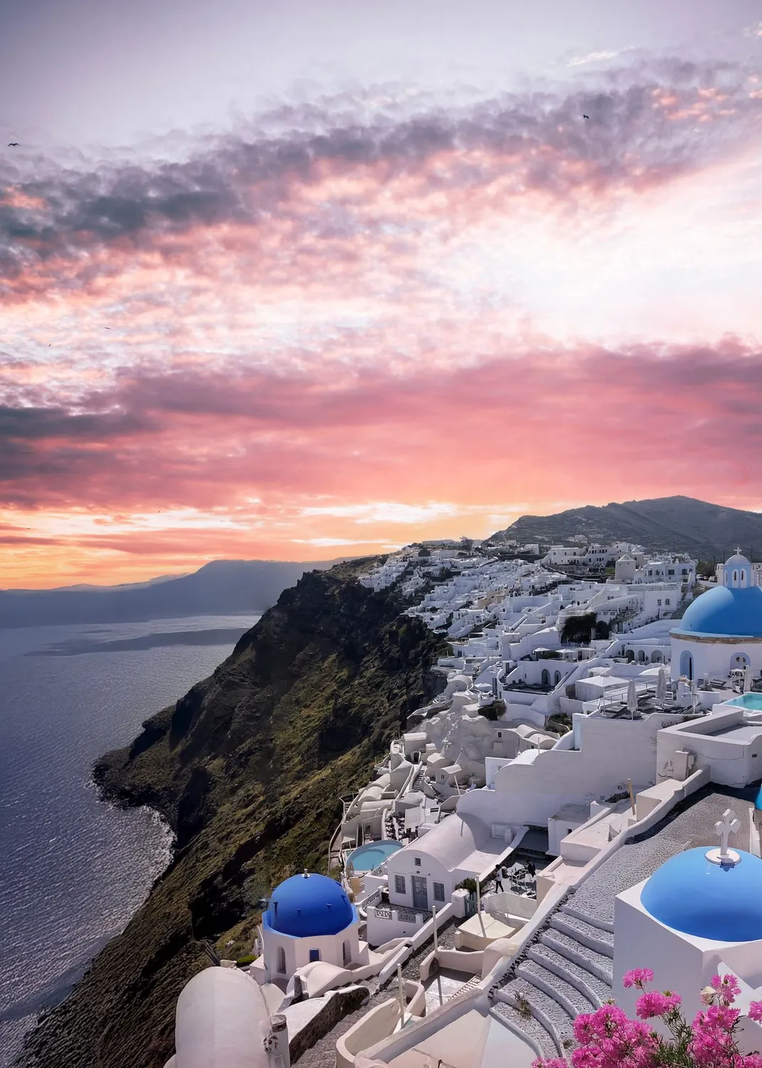 Pôr do sol sobre os domos azuis de Santorini, na Grécia